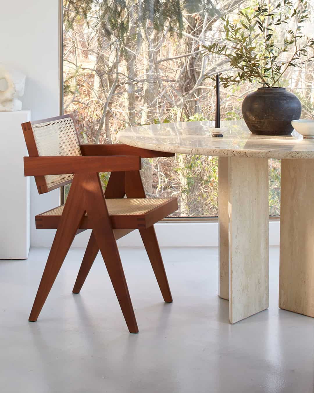 Sohnne dining room with a cane chair and travertine table