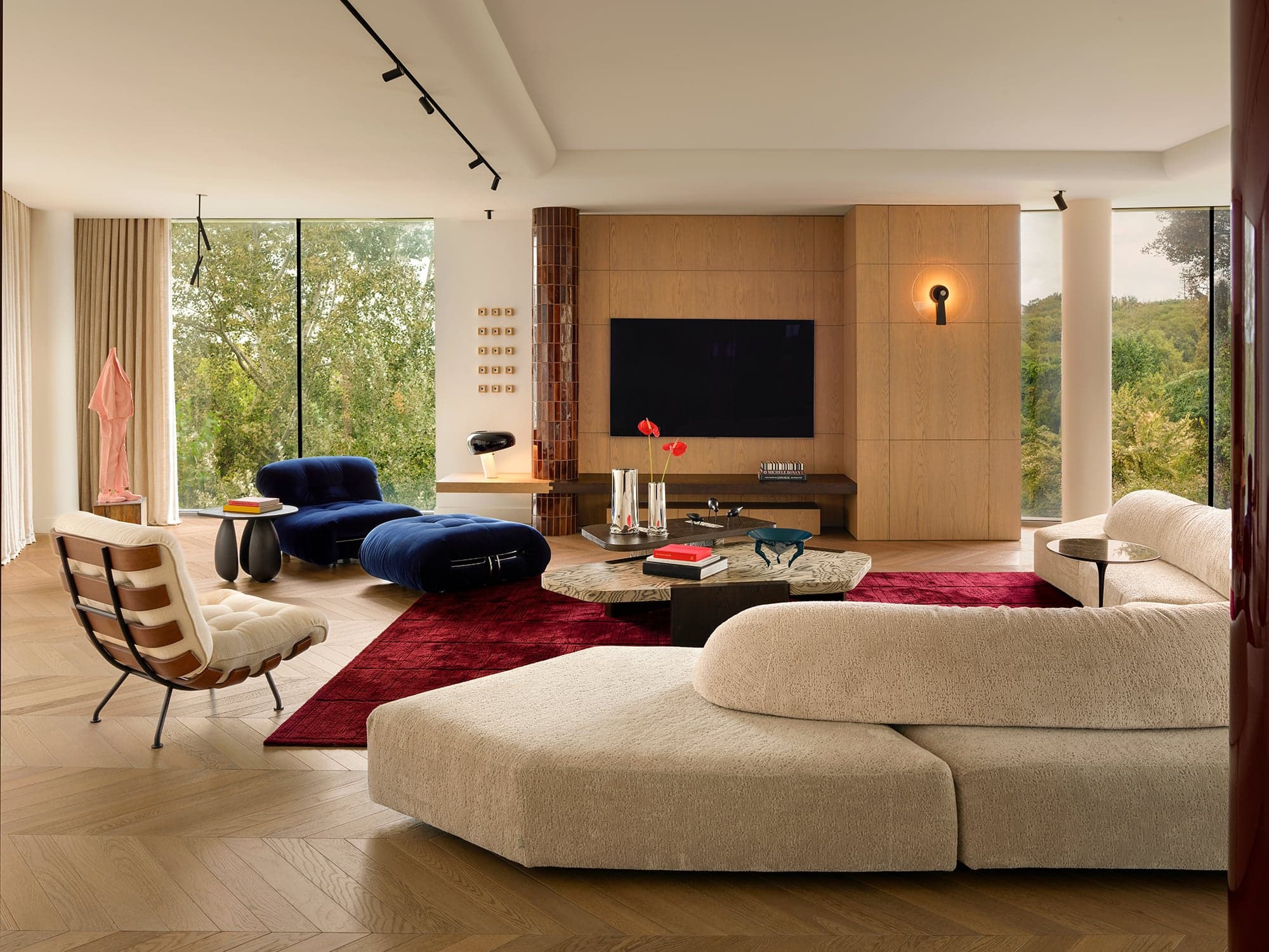 Living room with a Costela lounge chair, a blue velvet chaise and a boucle sectional