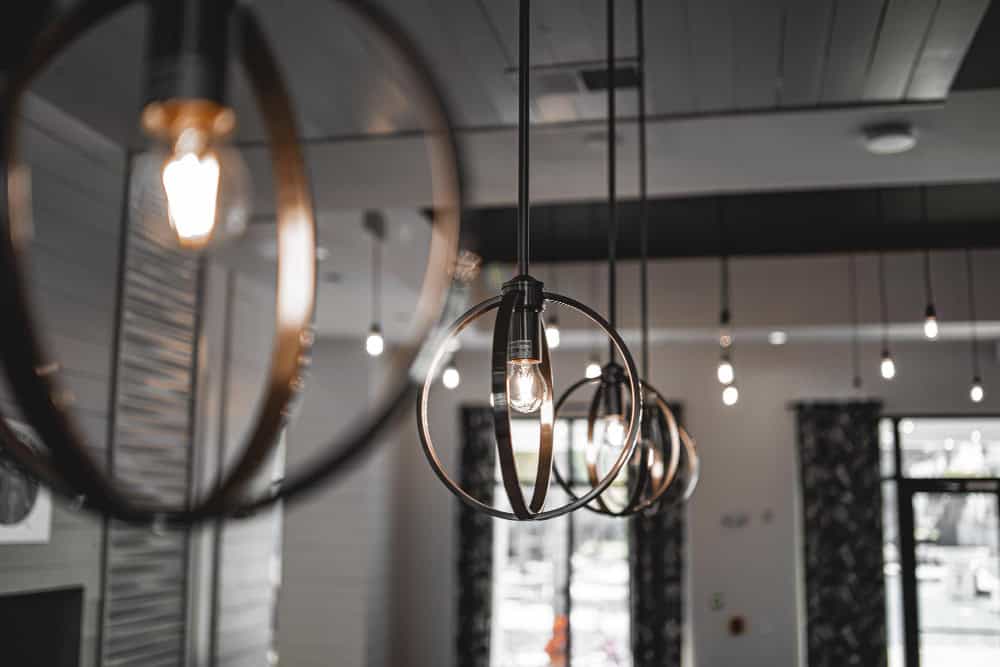 Pendant and floor lamps create a warm, layered glow. In addition, this lighting design supports split living room ideas that balance mood and usability.