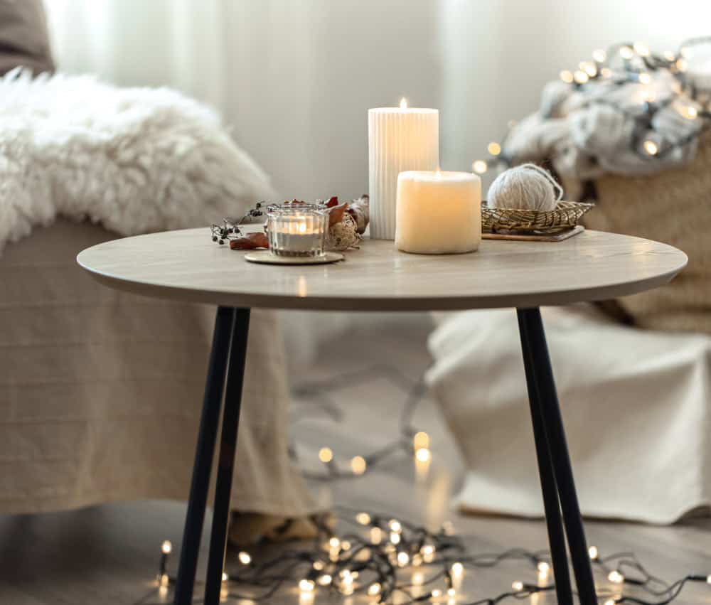 Pendant lighting and candles softly illuminating a marble dining table for a cozy evening mood.