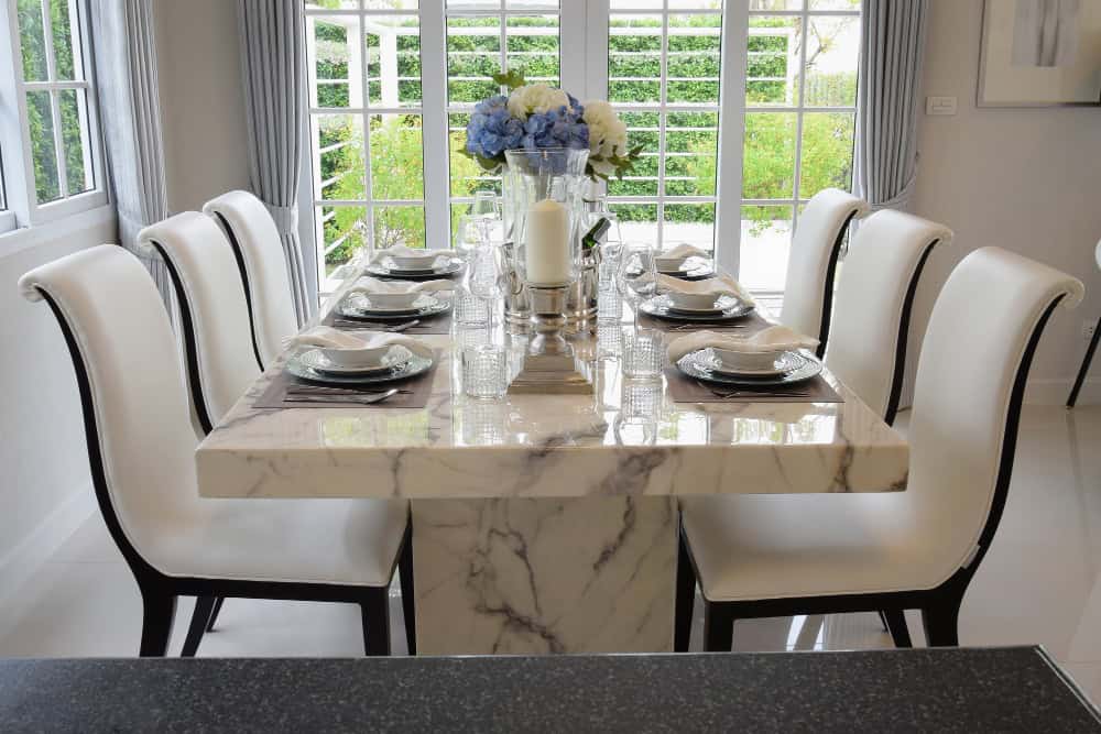 Porcelain dinnerware with gold accents arranged on marble dining table for a refined dining setup