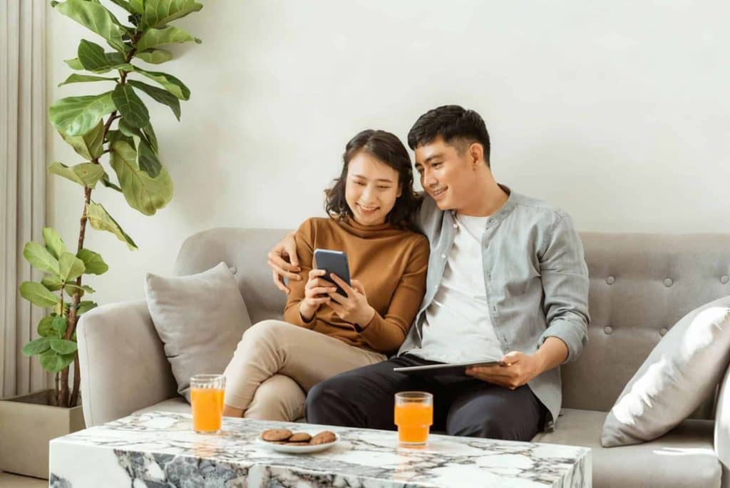 A couple relaxing on a sofa beside a marble table, showing ideal coffee table height and cozy living room balance.