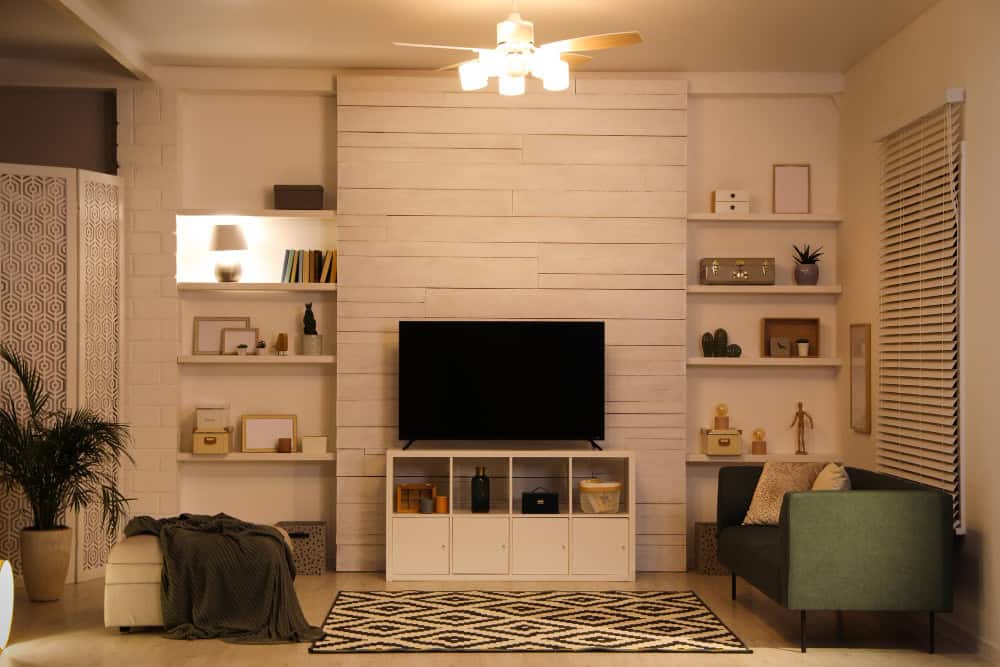 TV wall with sconces and hidden speakers showcasing ambient small living room ideas with TV.