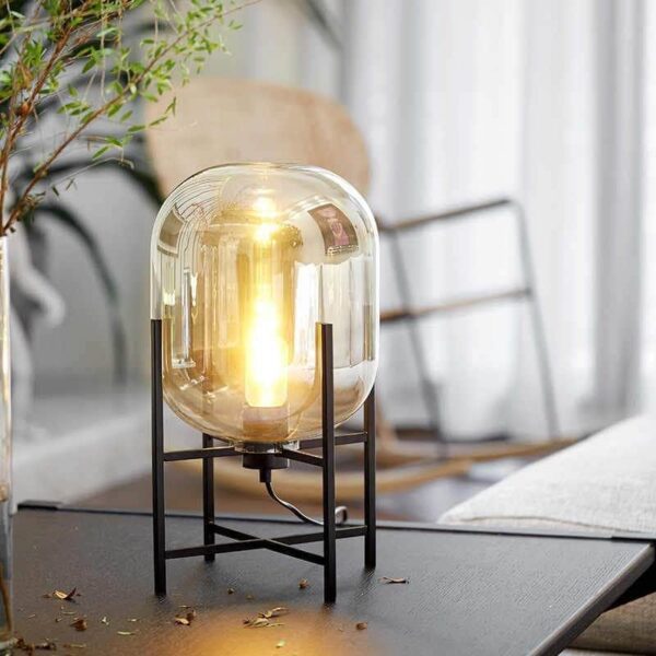 Pacifico Lamps - Elegant glass lamp with industrial frame, emitting warm ambiance.