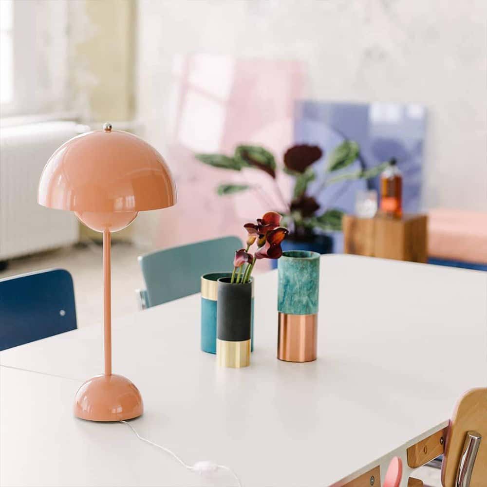 Flamingo Table Lamp features a slender body with a curved neck and a bulbous head, which houses the light source.