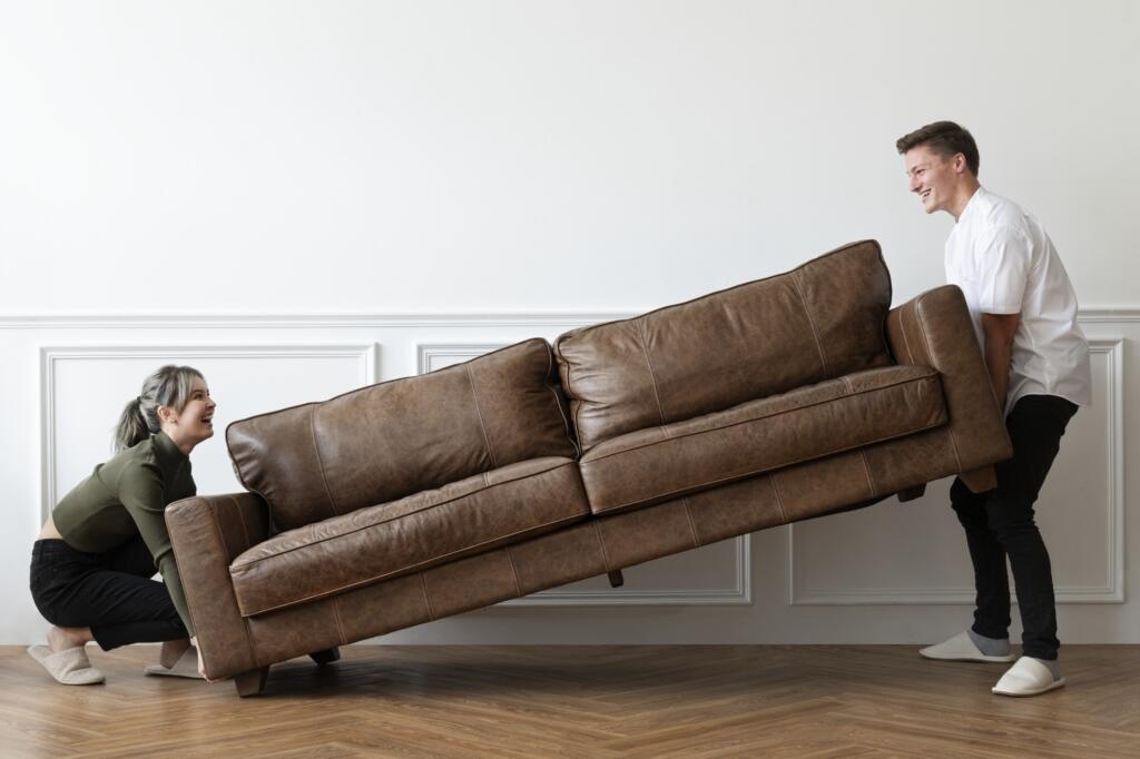 couple moving sofa new home