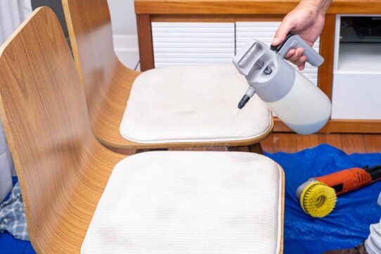 man spraying cleaning liquid chair upholstery scaled - How to Get Rid of Mold on Furniture