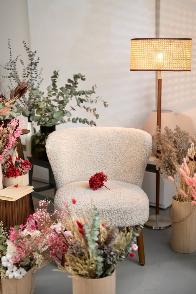 white boucle fabric chair in the middle of flower arrangement