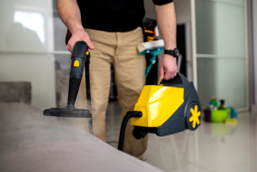 man doing cleaning work on sofa