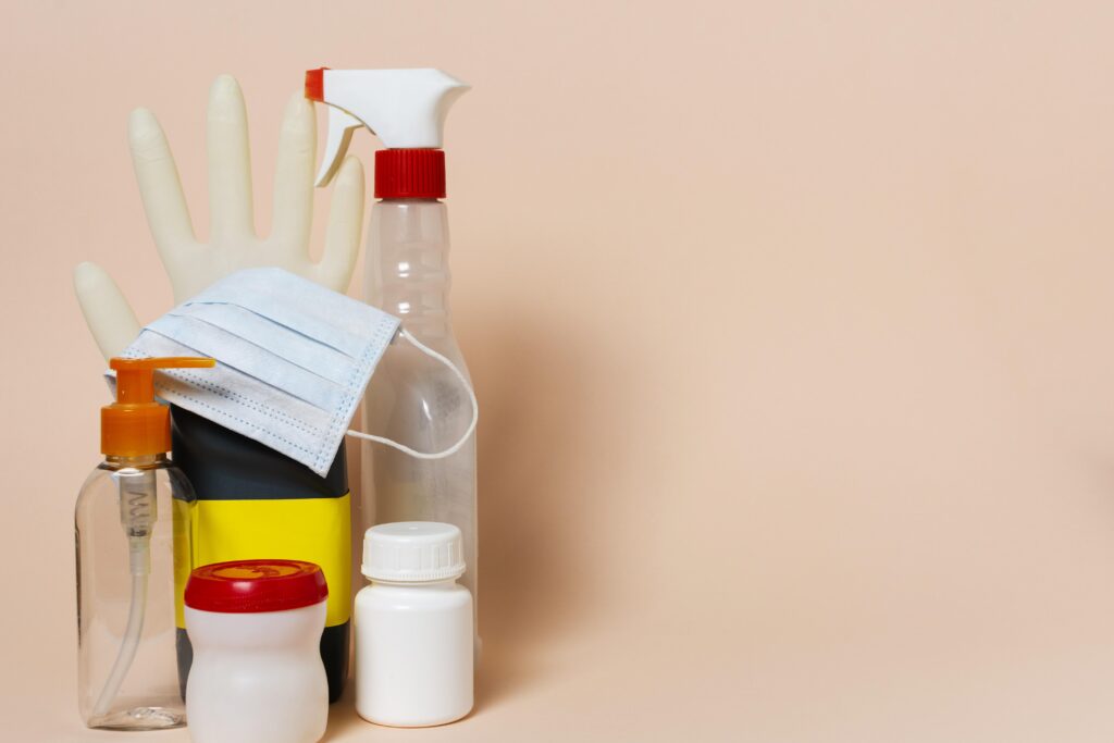 Bottles of cleaning supply, latex gloves, and surgical mask