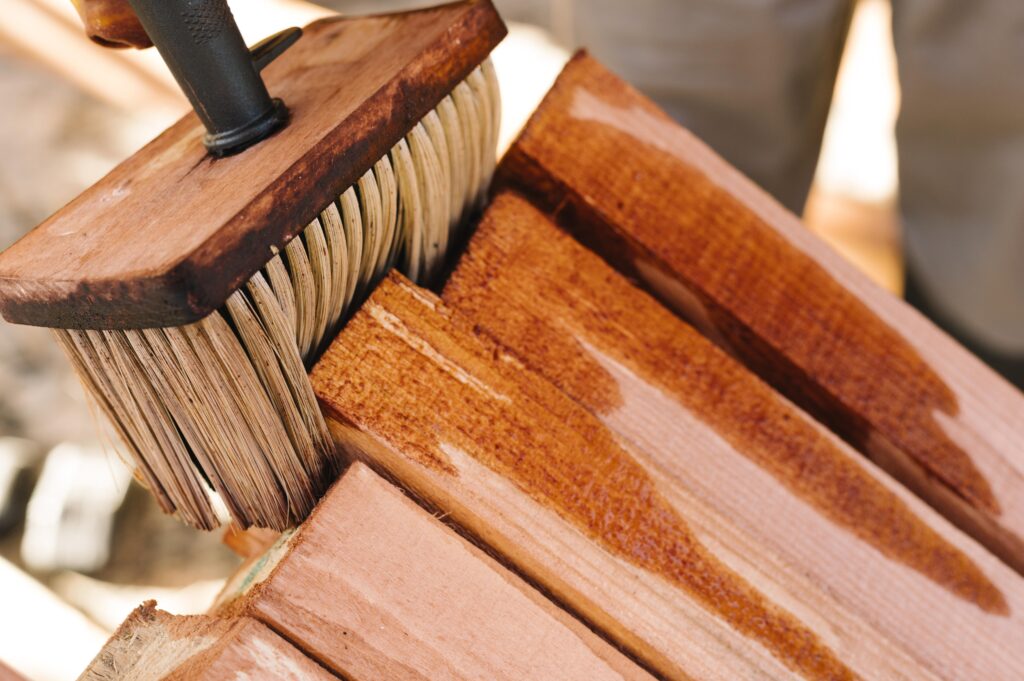 Person waxing wood with big brush