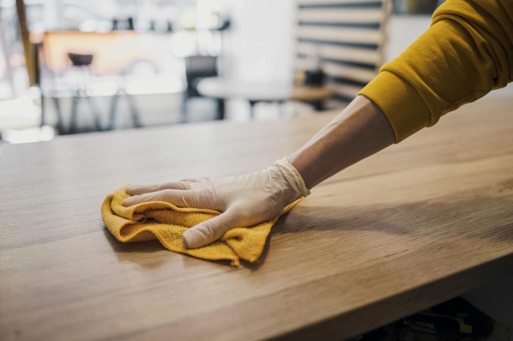 Cleaning wood furniture while wearing latex glove