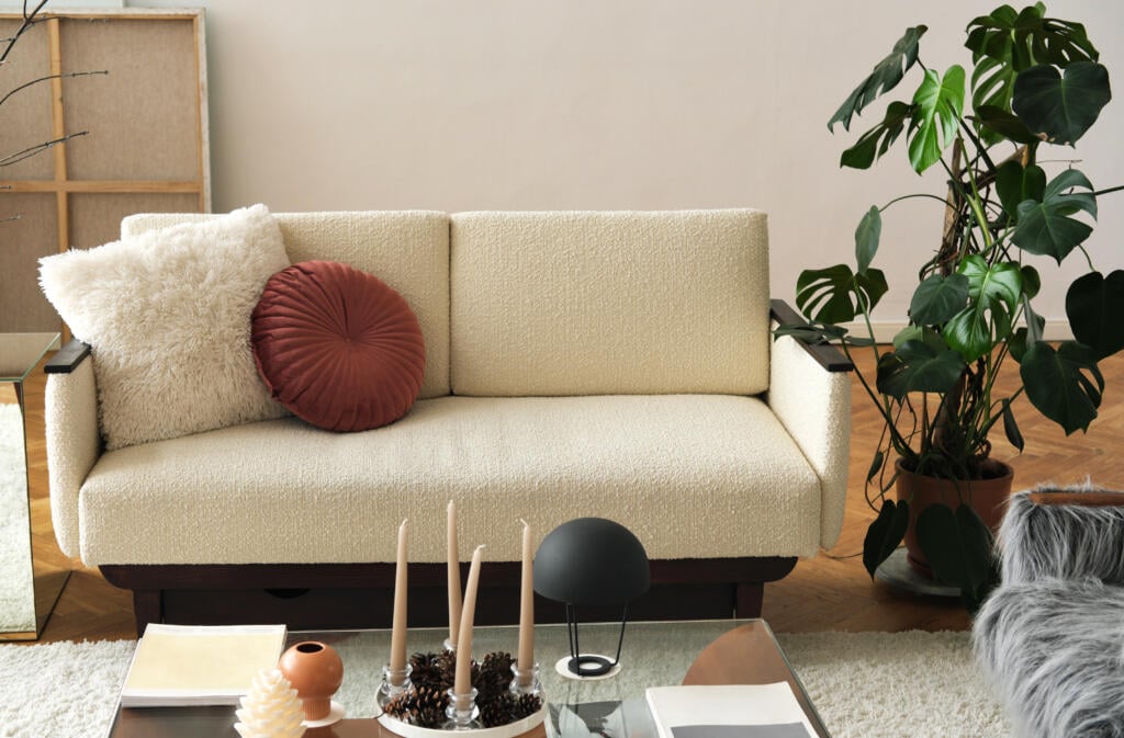 The stylish composition at living room interior with design beige sofa glass coffee table plants and elegant personal accessories Cozy apartment