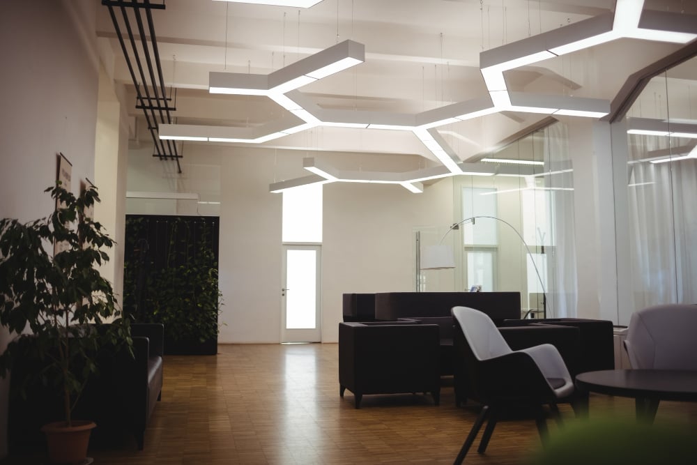 1963 | Sohnne® Ceiling beams and pendant lighting define separate areas from above. As a result, this example supports split living room ideas that use vertical space creatively.
