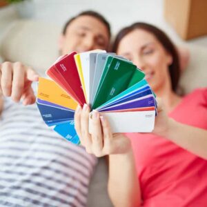 Homeowner testing paint swatches on foam boards to find the perfect home decor color palette under different lighting conditions.