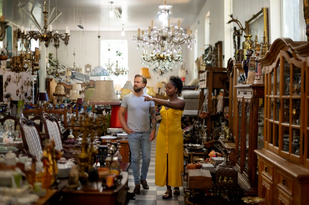 2149640711 | Sohnne® Couple browsing thrift store for apartment furniture cheap options and vintage decor finds.