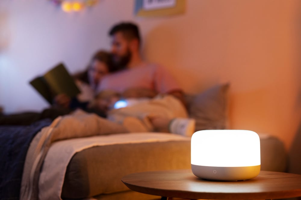 2150671560 | Sohnne® Warm apartment bedroom with a glowing table lamp and cozy lighting creating a relaxed evening atmosphere.