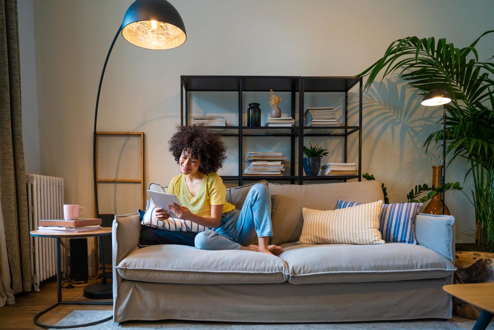 27337211 | Sohnne® Accent chair, bookshelf, and pendant light used as visual cues to define zones, showcasing smart split living room ideas for open homes.