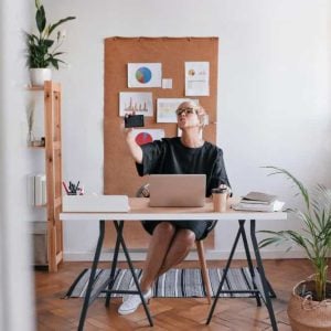 Person using workspace furniture in a bright, organized home office that promotes focus and clarity.