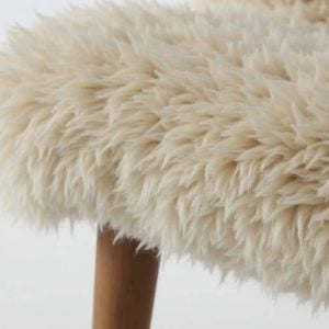 Close-up of Scandinavian sheepskin upholstery showing soft wool texture and craftsmanship in a clean, modern setting.