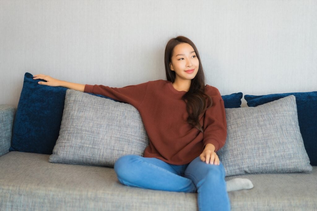 portrait beautiful young asian woman relax smile sofa living room interior | Sohnne® Convertible Japanese floor couch arranged as a reading lounge and daybed in a bright, open space.