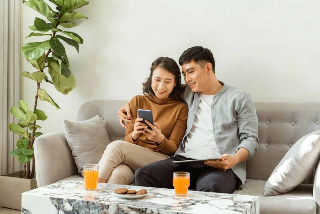 Coffee Table Height: How High Should It Really Be? 2 A Couple Relaxing On A Sofa Beside A Marble Table, Showing Ideal Coffee Table Height And Cozy Living Room Balance.