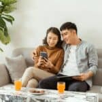 A couple relaxing on a sofa beside a marble table, showing ideal coffee table height and cozy living room balance.