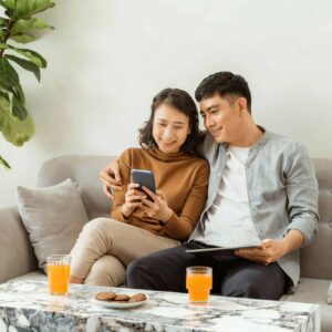 A couple relaxing on a sofa beside a marble table, showing ideal coffee table height and cozy living room balance.