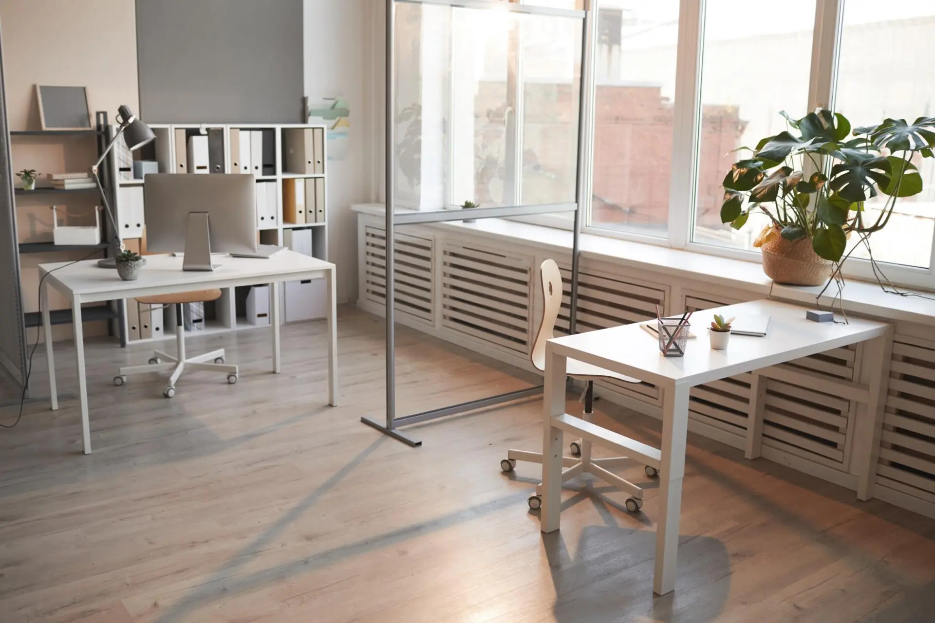 well-planned small office arrangement with double table setup, one in the corner and the other in front of window